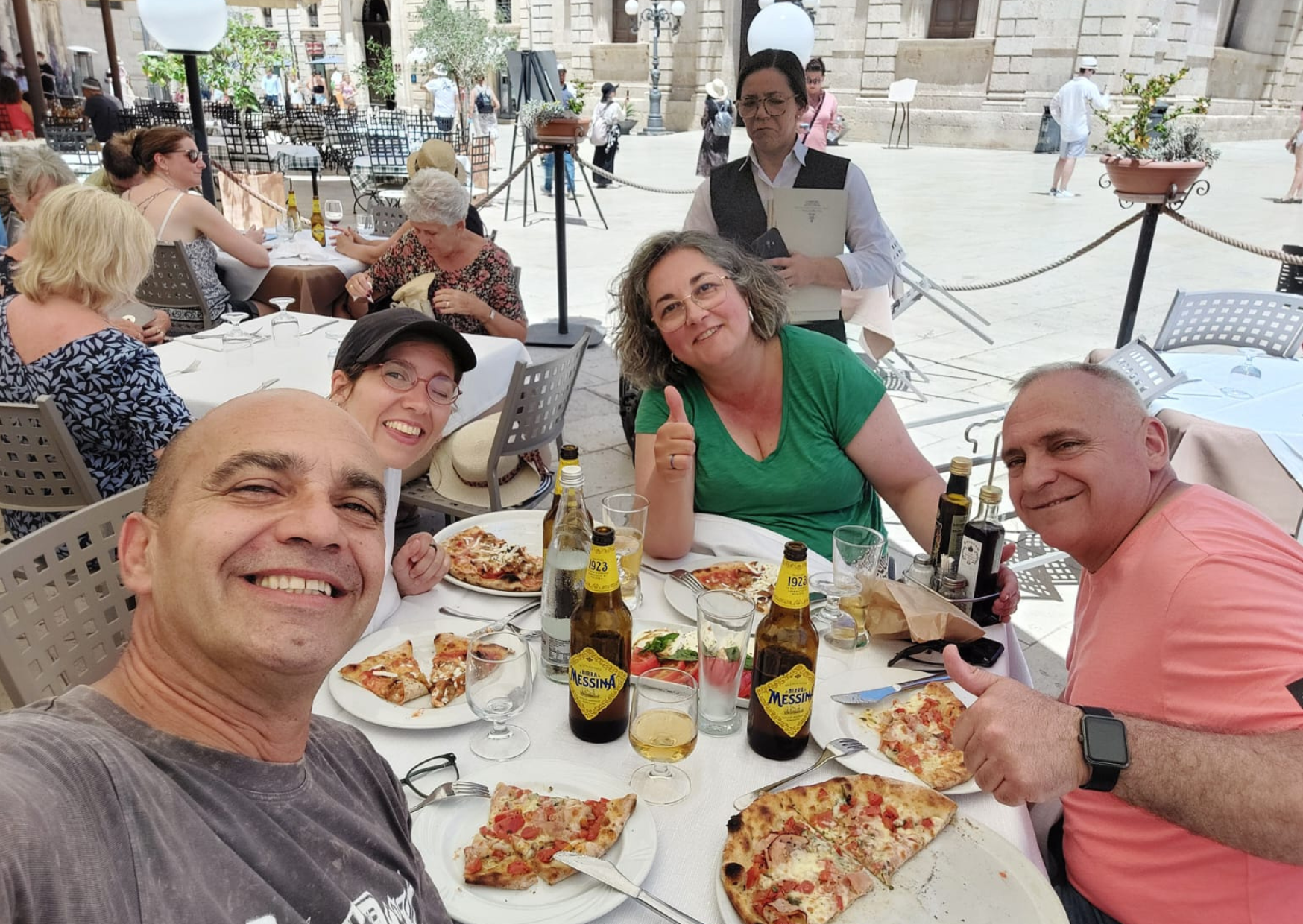Italia en silla de ruedas para foodies Cuatro personas comiendo pizza en Italia en silla de ruedas.