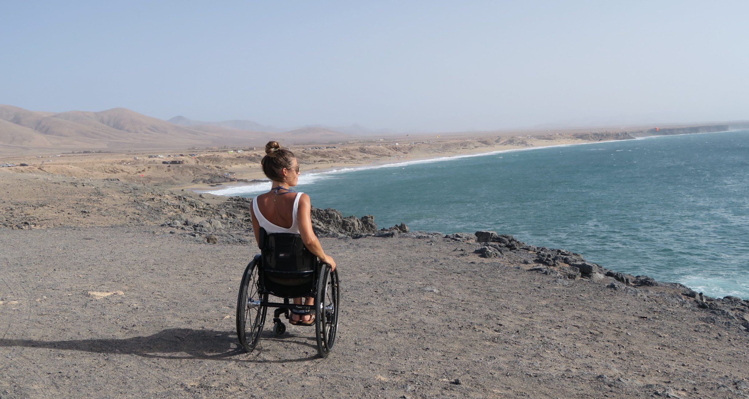 imagen de una usuaria de silla de ruedas mirando el mar desde un acantilado