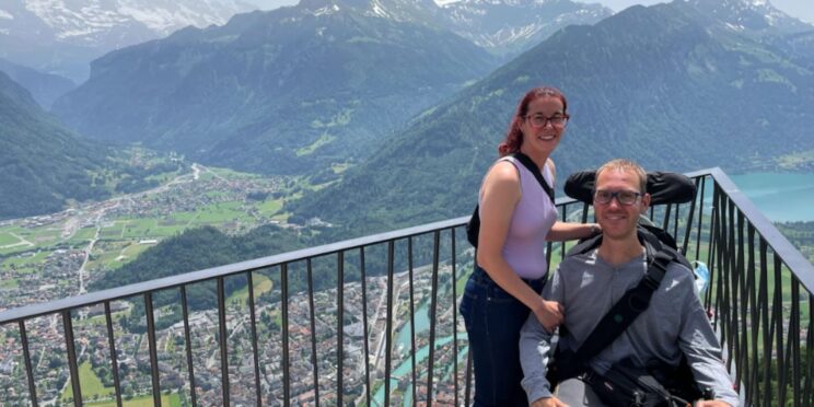 una pareja, uno de ellos usuario de silla de ruedas, en un mirador en suiza