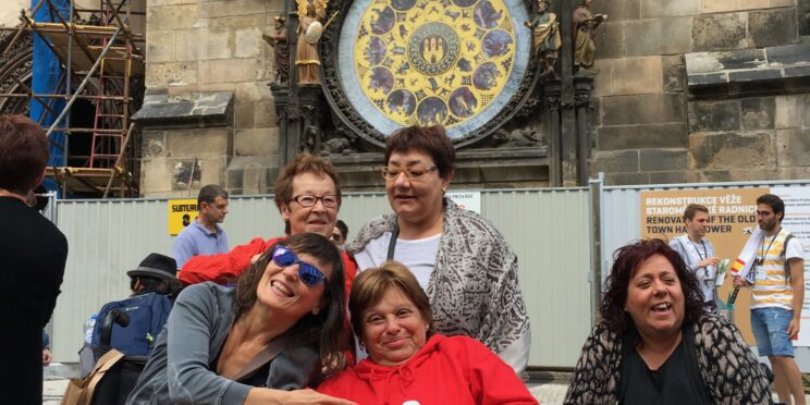 cuatro amigas disfrutando de un viaje adaptado a Praga ubicadas frente al reloj astronómico