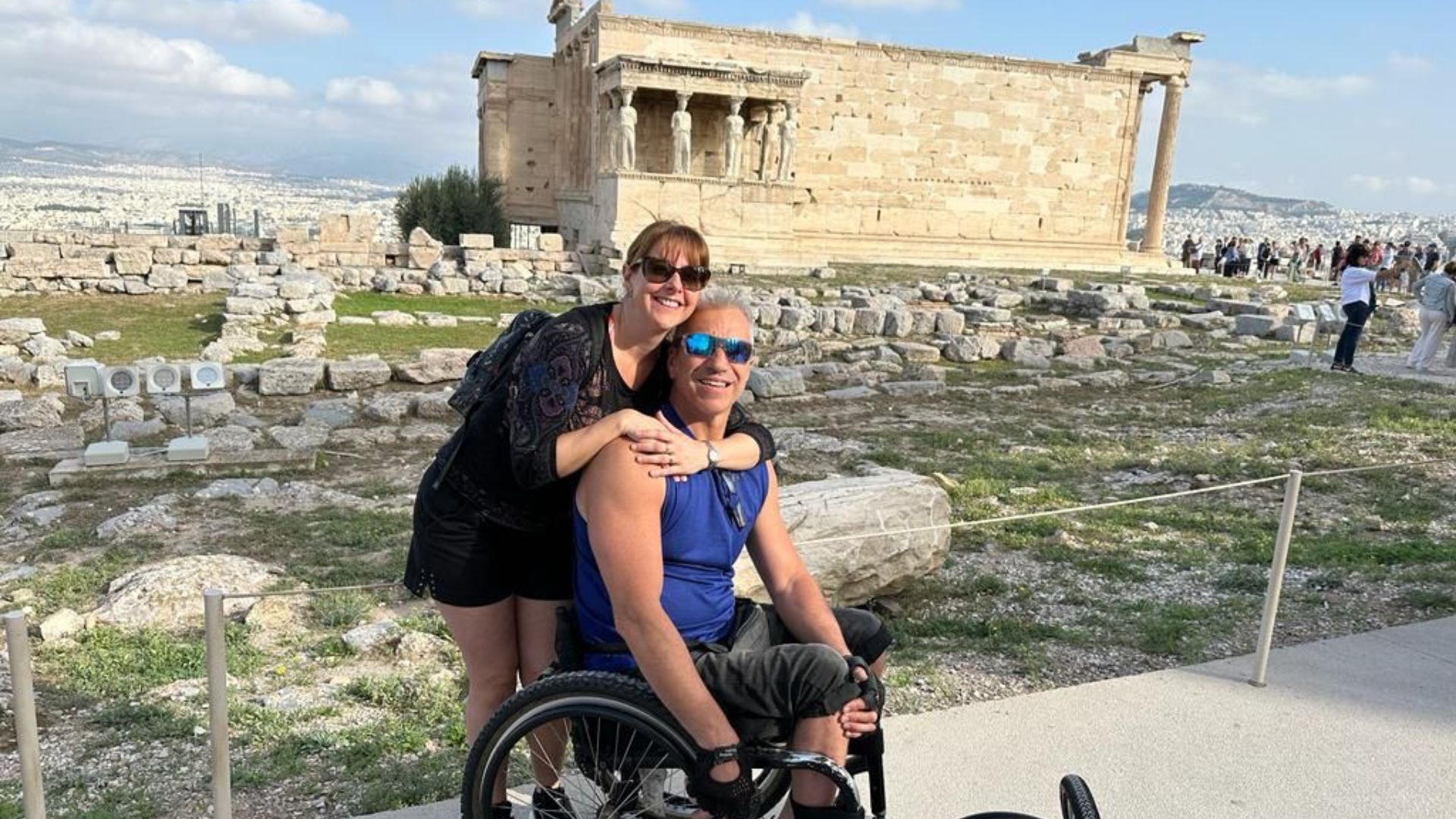 Una pareja, él en silla de ruedas, en la Acrópolis de Atenas en un viaje adaptado