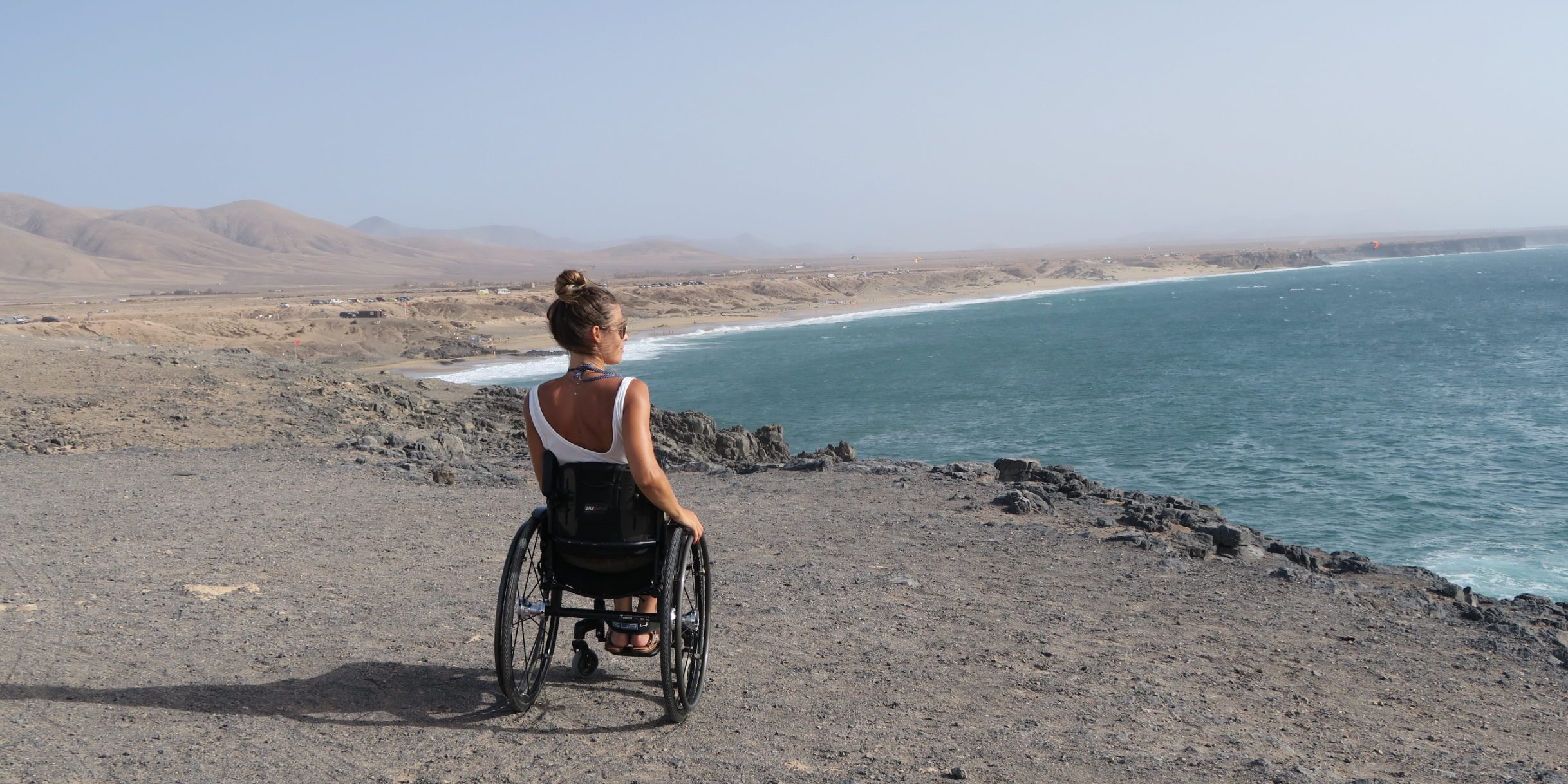 imagen de una usuaria de silla de ruedas mirando el mar desde un acantilado