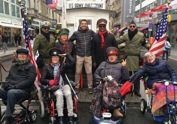 Un grupo de usuarias de silla de ruedas junto a los militares en el check point charlie en Berlin