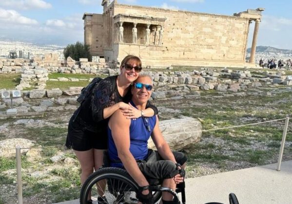 Una pareja, él en silla de ruedas, en la Acrópolis de Atenas en un viaje adaptado