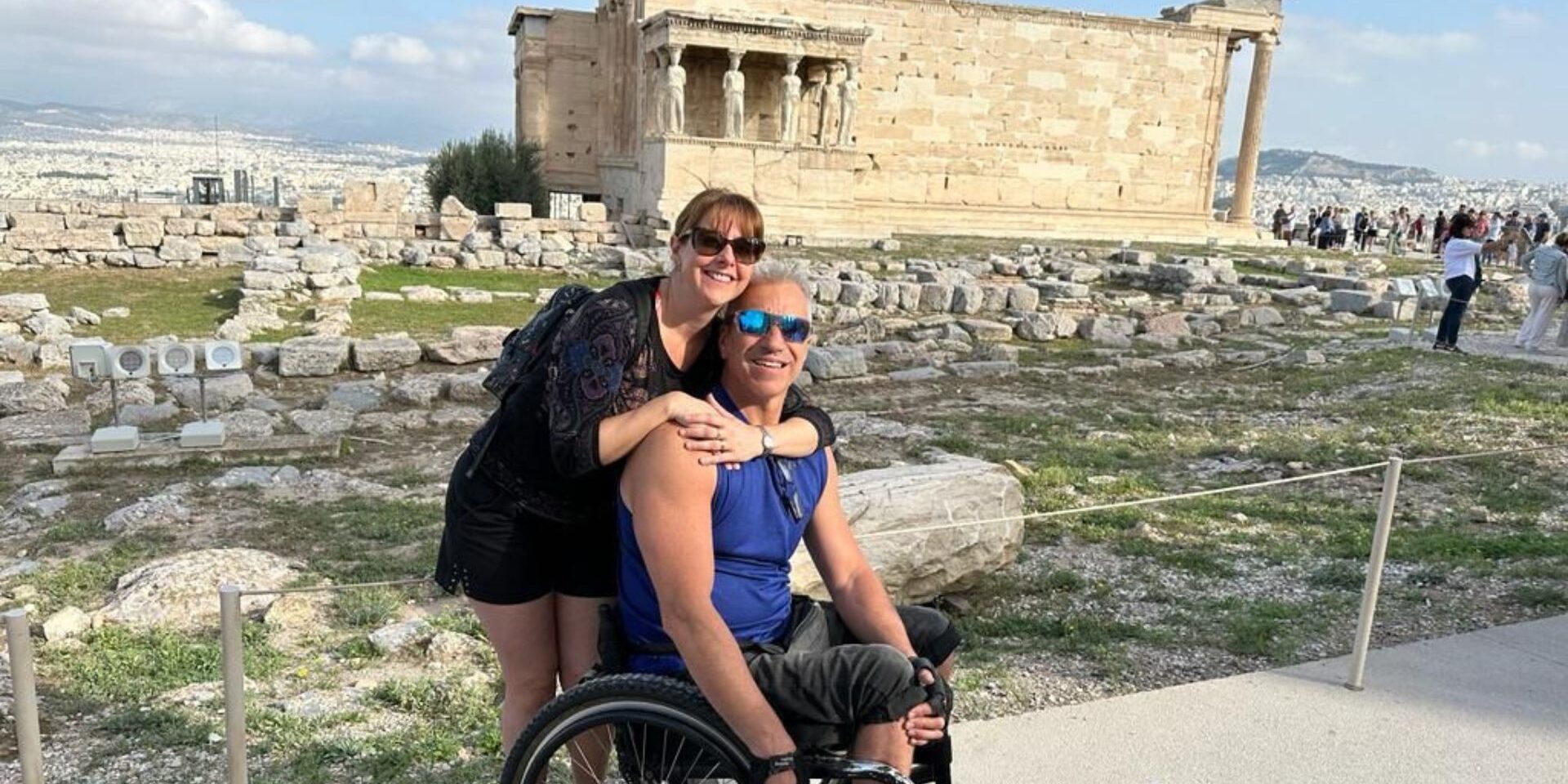 Una pareja, él en silla de ruedas, en la Acrópolis de Atenas en un viaje adaptado