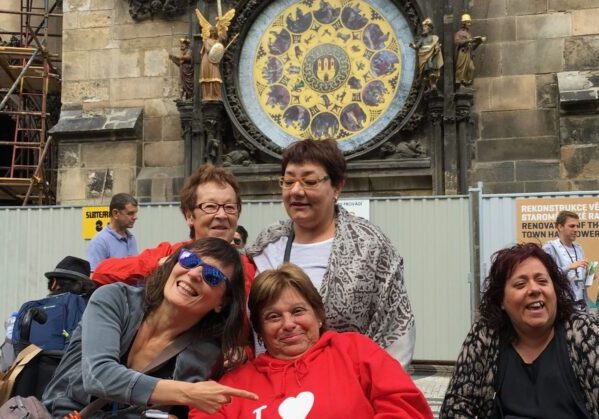 cuatro amigas disfrutando de un viaje adaptado a Praga ubicadas frente al reloj astronómico