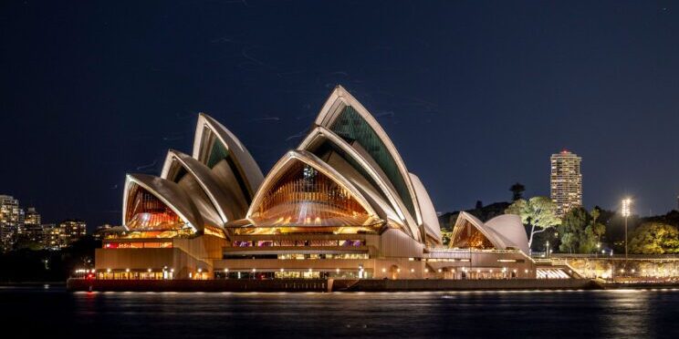 Imagen de la Ópera de Sídney iluminada por la noche
