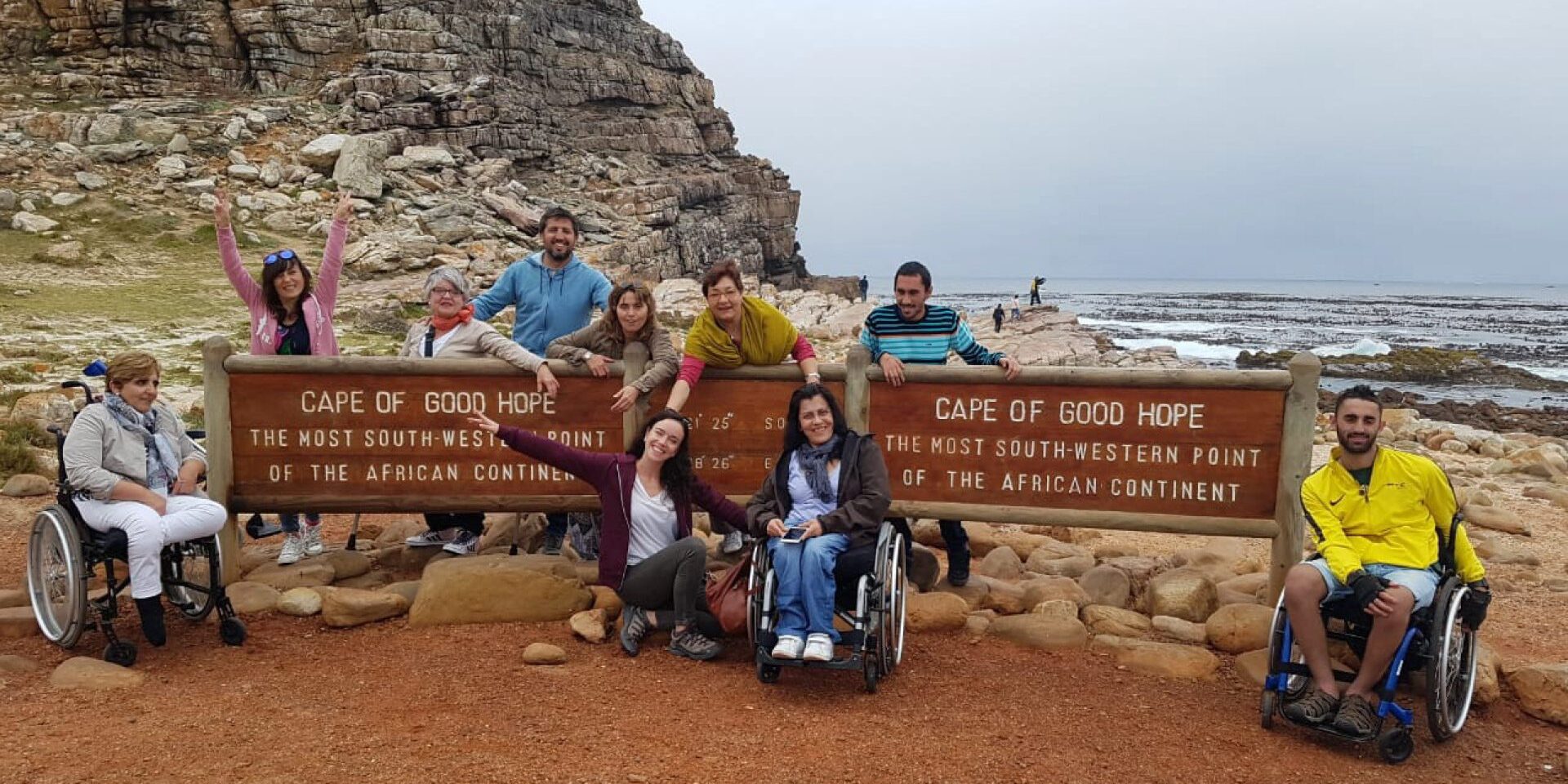 Un grupo de viajeros usuarios de silla de ruedas en el Cabo de buena Esperanza en un viaje a sudáfrica